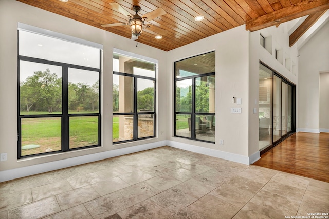 empty room with lofted ceiling with beams, wooden ceiling, and ceiling fan