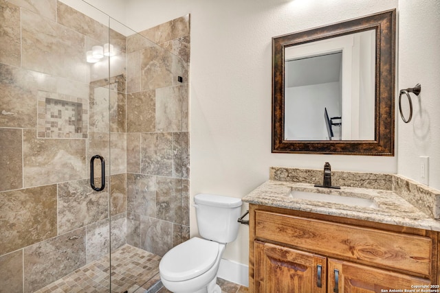 bathroom with vanity, toilet, and a shower with shower door