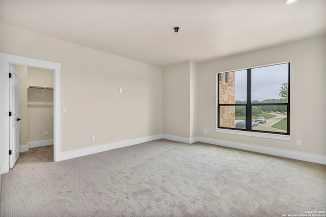 unfurnished room featuring light carpet