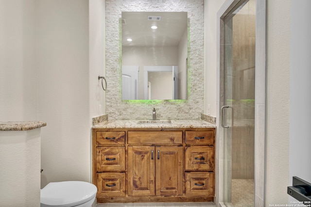 bathroom with a shower with door, vanity, tasteful backsplash, and toilet