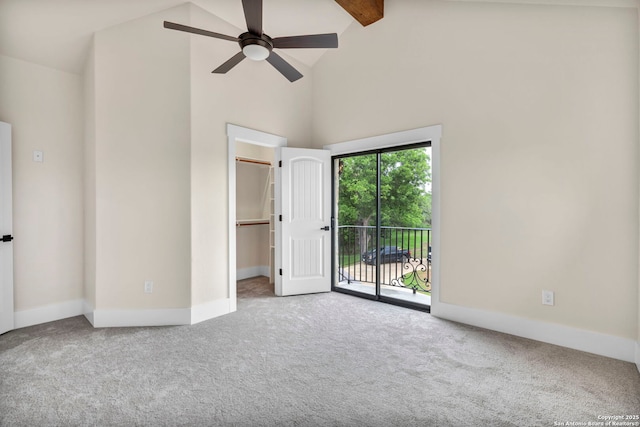 unfurnished bedroom with high vaulted ceiling, carpet floors, a spacious closet, access to exterior, and beam ceiling