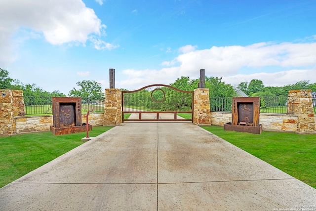 view of gate with a lawn