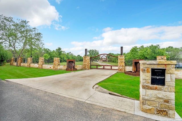 view of gate with a yard