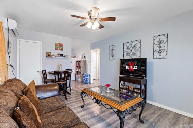 living room with hardwood / wood-style floors, a wall unit AC, and ceiling fan