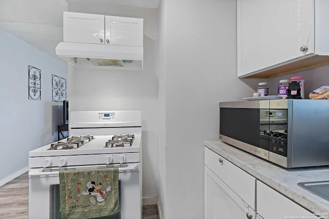 kitchen featuring premium range hood, white range with gas cooktop, white cabinets, and light hardwood / wood-style flooring