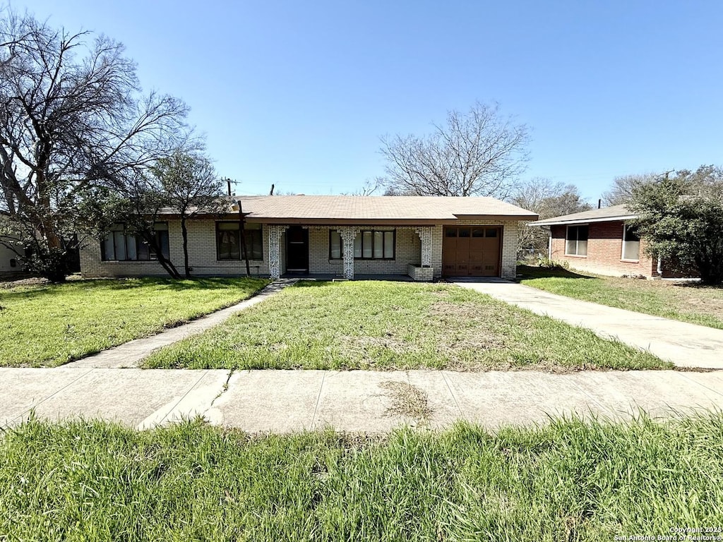 ranch-style home featuring a garage and a front lawn