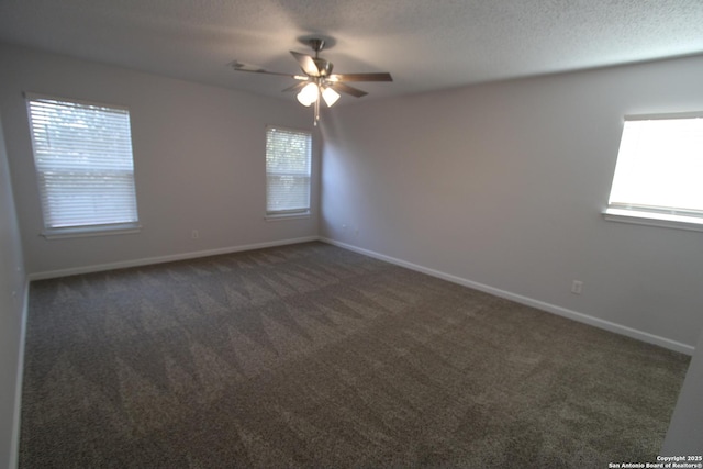 carpeted empty room featuring ceiling fan, plenty of natural light, and a textured ceiling