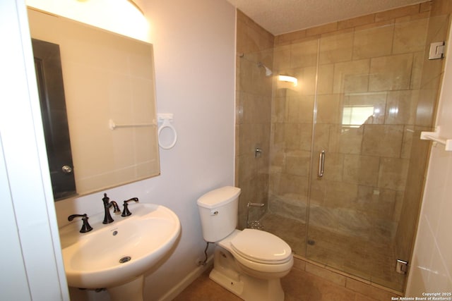 bathroom featuring toilet, a shower with door, and sink