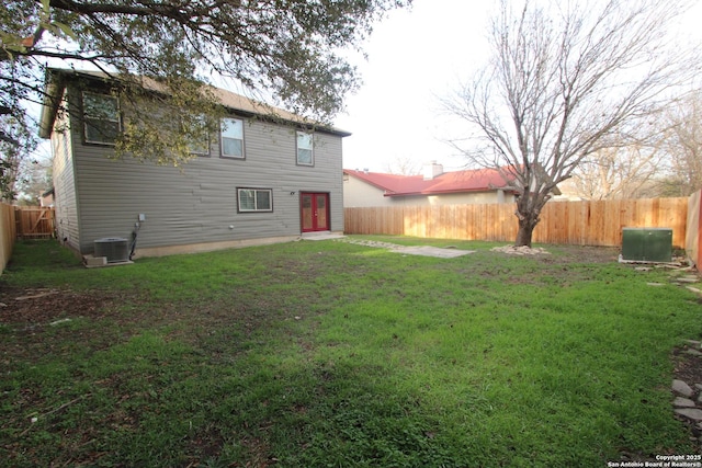 back of house with cooling unit and a yard