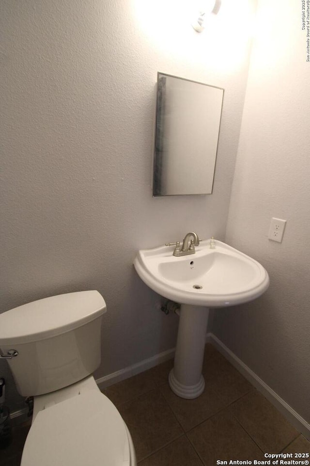 bathroom featuring toilet and tile patterned flooring