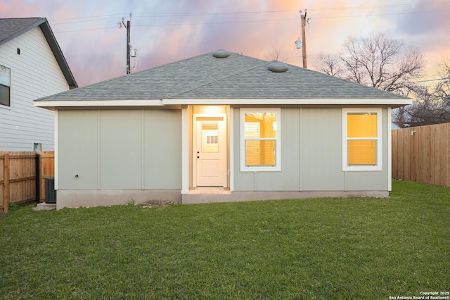 back house at dusk with a yard