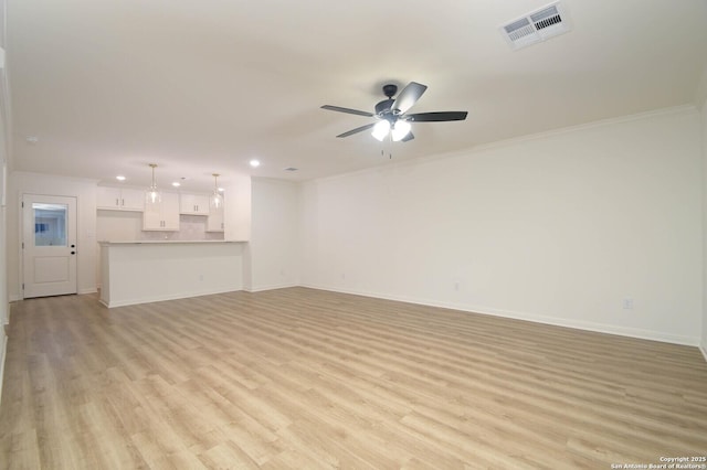 unfurnished living room with ceiling fan, ornamental molding, and light wood-type flooring