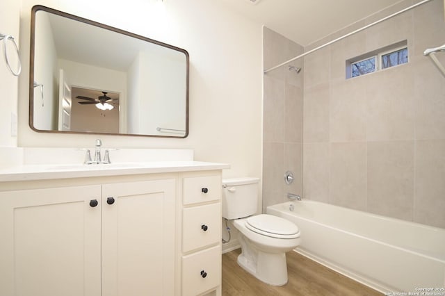 full bathroom featuring tiled shower / bath, hardwood / wood-style floors, vanity, and toilet