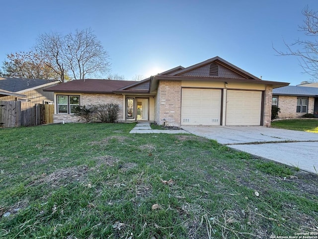 single story home featuring a garage and a front lawn