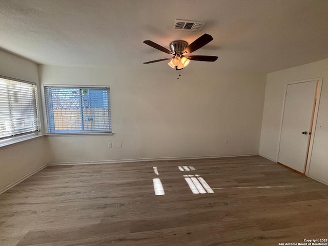 empty room with hardwood / wood-style floors and ceiling fan