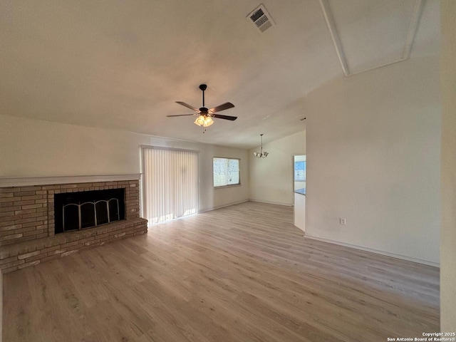 unfurnished living room featuring ceiling fan, a fireplace, vaulted ceiling, and light wood-type flooring