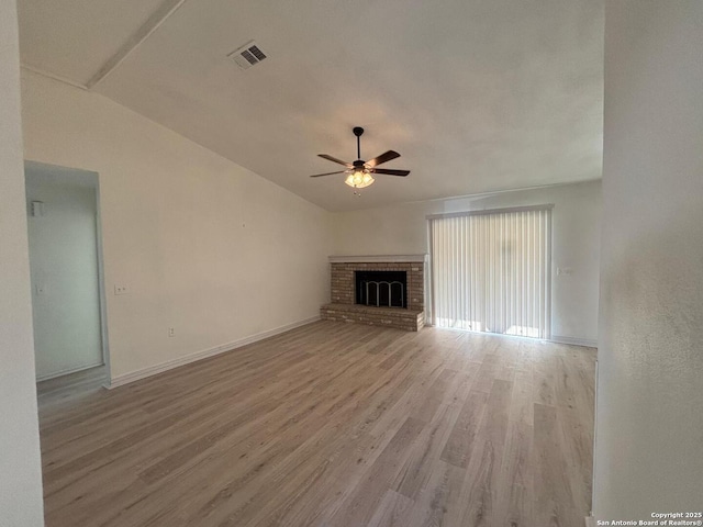 unfurnished living room featuring a fireplace, light hardwood / wood-style floors, ceiling fan, and vaulted ceiling