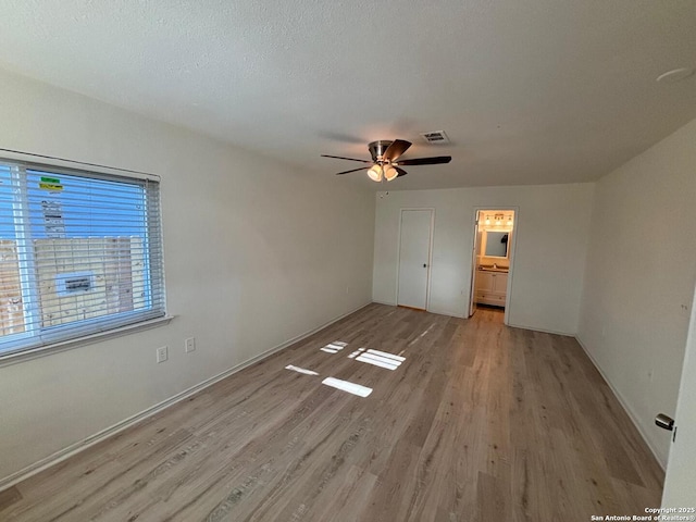 unfurnished bedroom with ceiling fan, ensuite bathroom, light hardwood / wood-style floors, and a textured ceiling