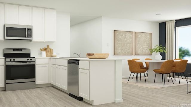 kitchen with sink, stainless steel appliances, light hardwood / wood-style floors, white cabinets, and kitchen peninsula