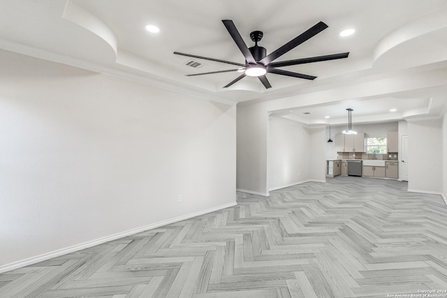 unfurnished living room featuring ceiling fan and a raised ceiling