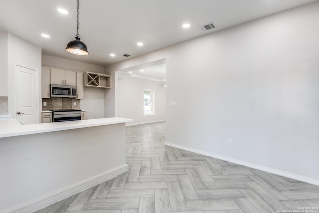 kitchen with stove, light parquet flooring, decorative light fixtures, kitchen peninsula, and tasteful backsplash