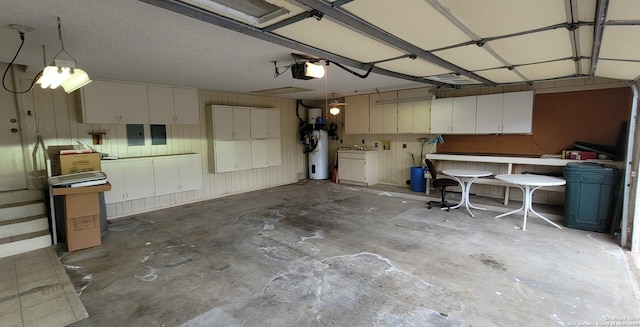 garage with a garage door opener, electric panel, and water heater