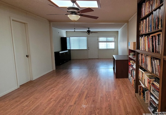 interior space featuring ornamental molding, light hardwood / wood-style flooring, and a textured ceiling