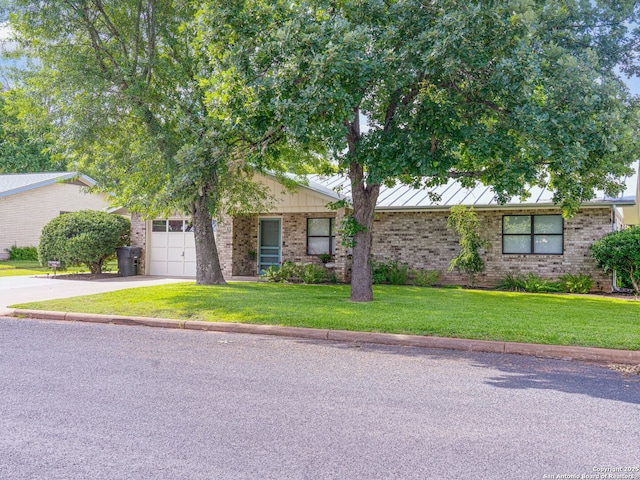 view of front of property with a garage and a front lawn