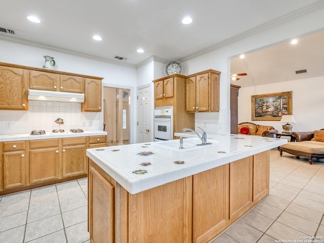 kitchen with light tile patterned flooring, sink, decorative backsplash, tile counters, and white appliances