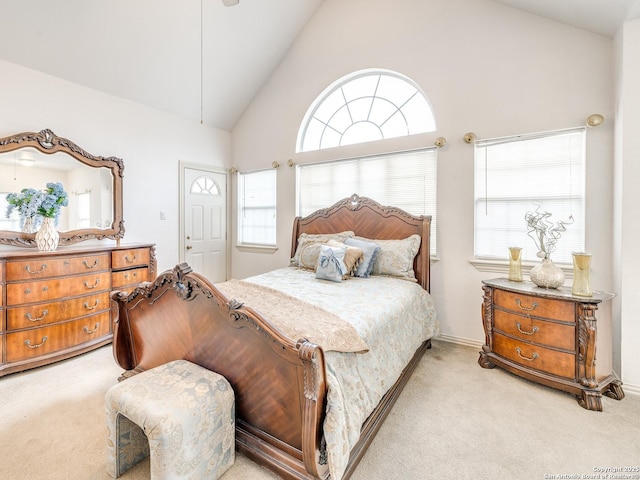 bedroom with high vaulted ceiling and light colored carpet