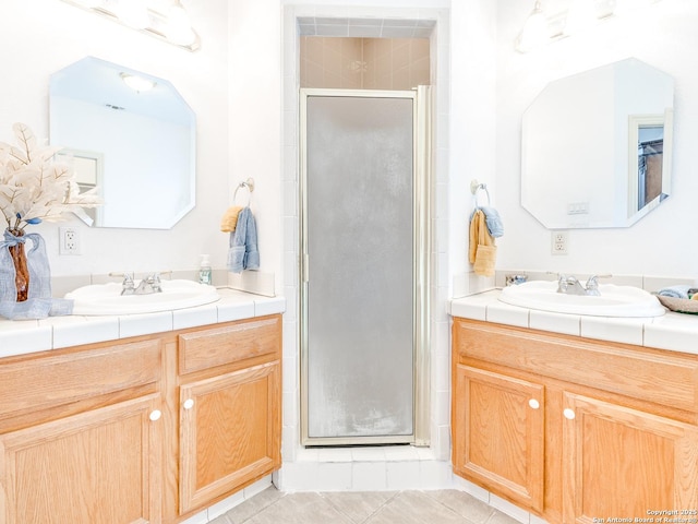 bathroom featuring tile patterned floors, a shower with shower door, and vanity