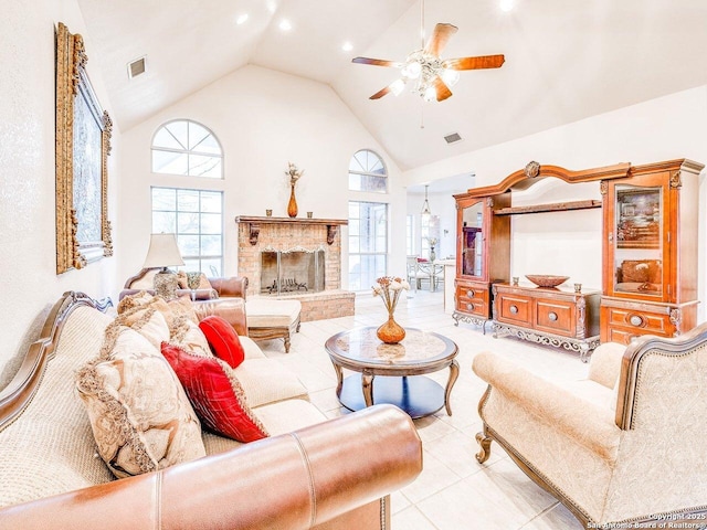 living room with a brick fireplace, high vaulted ceiling, and ceiling fan