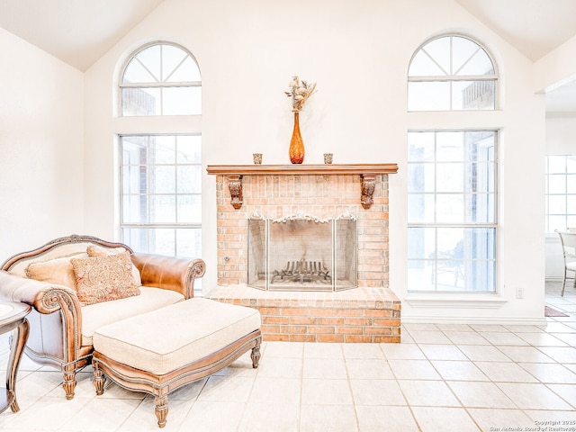 tiled living room with high vaulted ceiling, a healthy amount of sunlight, and a fireplace