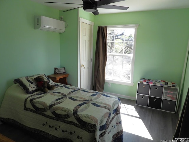 bedroom featuring multiple windows, an AC wall unit, hardwood / wood-style flooring, and ceiling fan