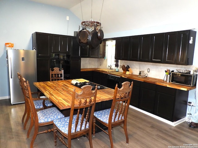 kitchen featuring dark hardwood / wood-style flooring, vaulted ceiling, black appliances, and tasteful backsplash