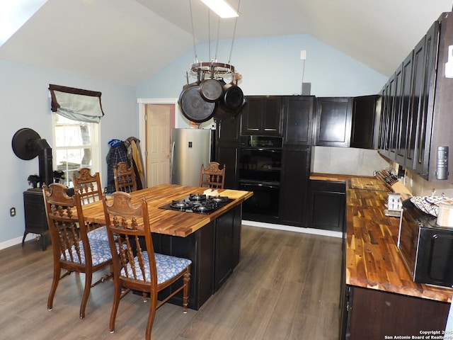 kitchen with dark wood-type flooring, lofted ceiling, butcher block countertops, and black appliances