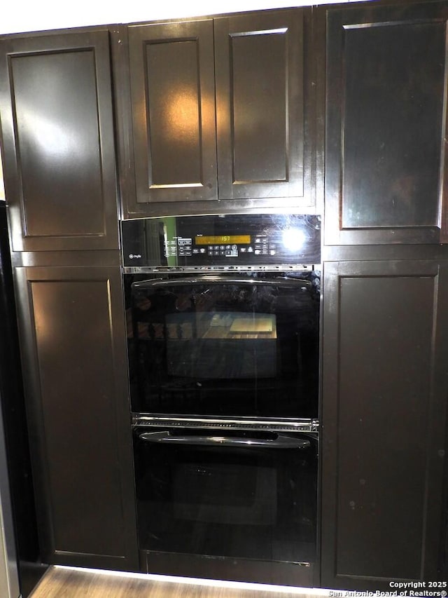 room details with black double oven and dark brown cabinets