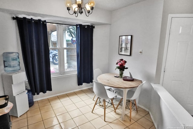 tiled dining area featuring a chandelier and a textured ceiling