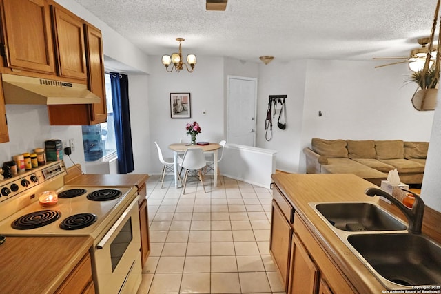 kitchen with electric range oven, sink, hanging light fixtures, light tile patterned floors, and a textured ceiling