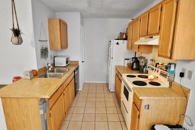 kitchen featuring sink, white appliances, light tile patterned floors, and a textured ceiling