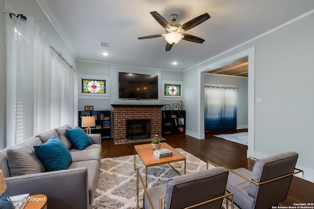 living room featuring a brick fireplace, crown molding, and dark wood-type flooring