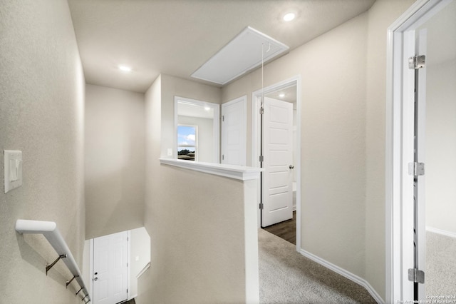 hallway with dark colored carpet