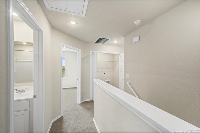 hallway with carpet flooring and sink