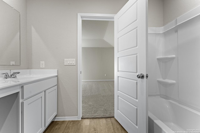 bathroom featuring vanity, hardwood / wood-style floors, and  shower combination