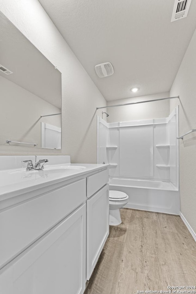 full bathroom featuring hardwood / wood-style flooring, shower / tub combination, vanity, and toilet