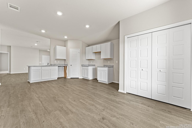 kitchen featuring white cabinetry, light hardwood / wood-style floors, and a center island
