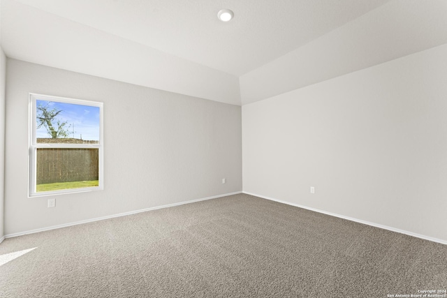 unfurnished room with lofted ceiling and carpet floors
