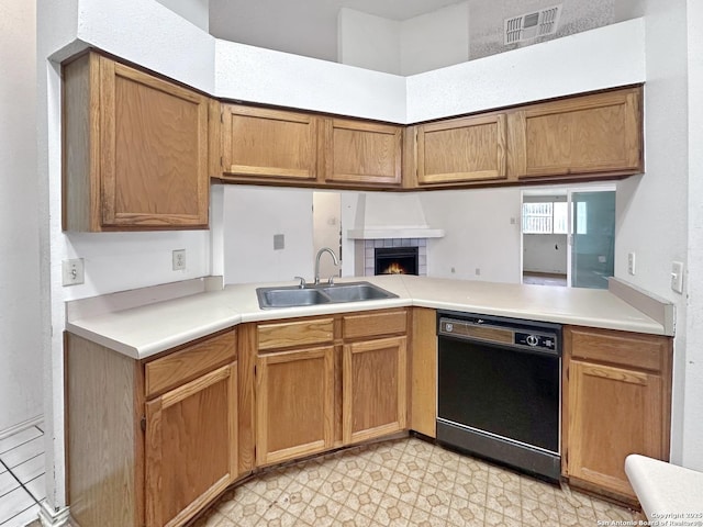 kitchen with black dishwasher, sink, and a fireplace