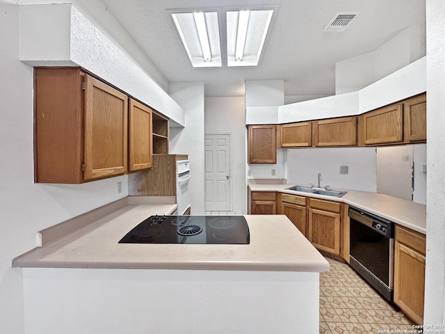 kitchen with a skylight, sink, kitchen peninsula, and black appliances