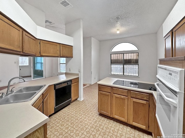 kitchen featuring kitchen peninsula, sink, a textured ceiling, and black appliances